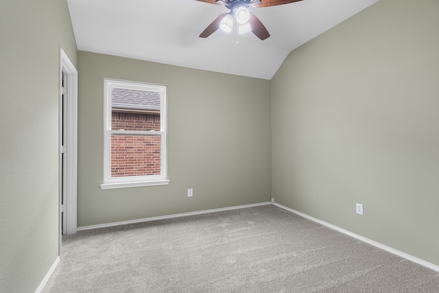 carpeted empty room featuring vaulted ceiling and ceiling fan