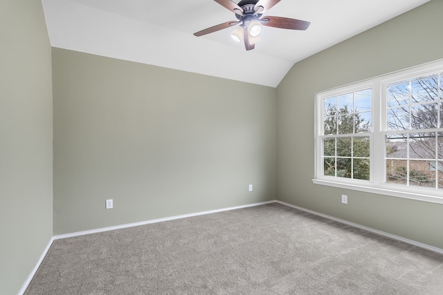 carpeted spare room featuring vaulted ceiling and ceiling fan