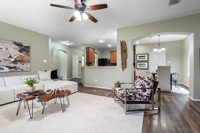 living room featuring ceiling fan with notable chandelier and light wood-type flooring