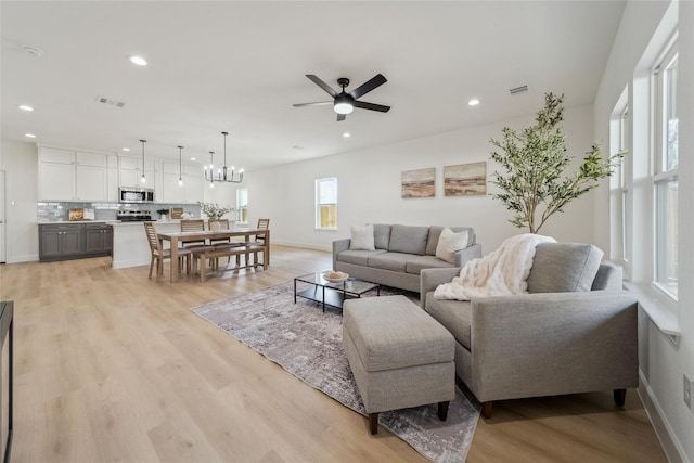 living area featuring light wood finished floors, baseboards, visible vents, and recessed lighting