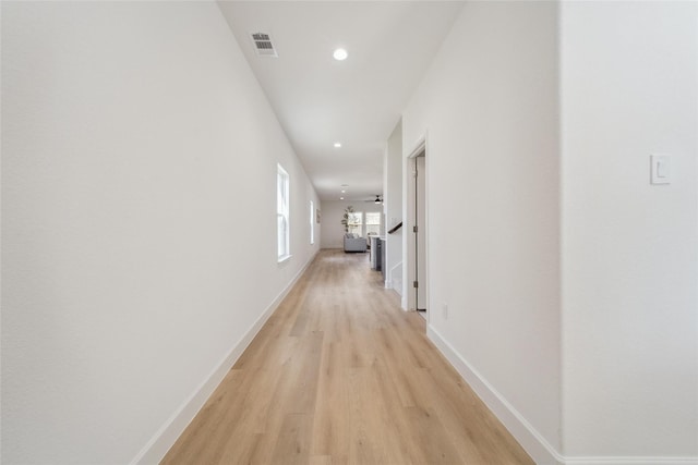 hall with light wood-style floors, recessed lighting, visible vents, and baseboards