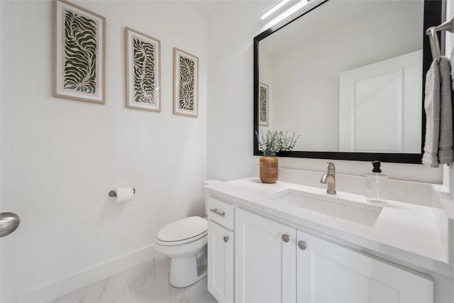 bathroom featuring toilet, marble finish floor, baseboards, and vanity