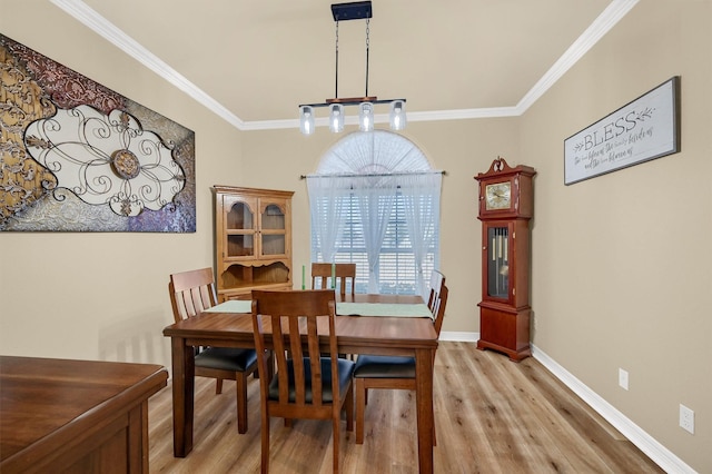 dining area with light hardwood / wood-style floors and ornamental molding