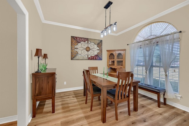 dining space featuring ornamental molding and light hardwood / wood-style flooring