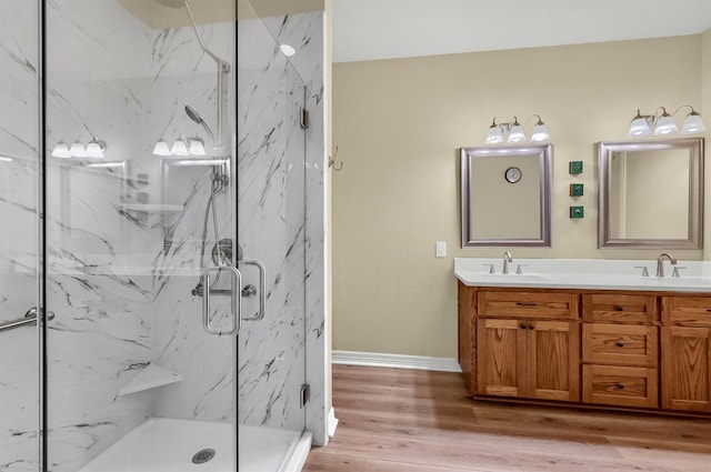 bathroom with hardwood / wood-style floors, walk in shower, and vanity