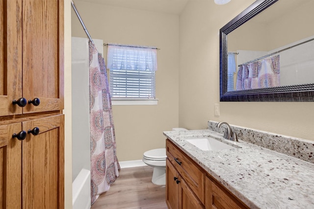 full bathroom with shower / bath combo with shower curtain, hardwood / wood-style floors, toilet, and vanity