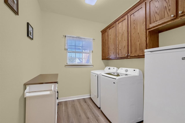 laundry room featuring light hardwood / wood-style floors, cabinets, and independent washer and dryer