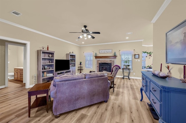 living room featuring ceiling fan, ornamental molding, light hardwood / wood-style floors, and a fireplace