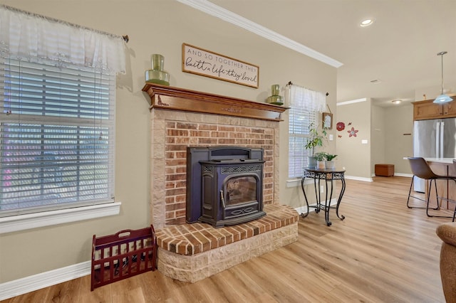 living room with light wood-type flooring, a wood stove, and ornamental molding