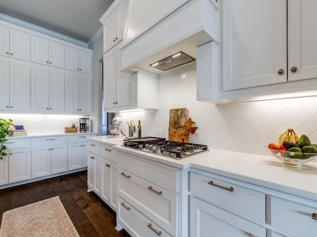 kitchen featuring premium range hood, white cabinetry, backsplash, dark hardwood / wood-style floors, and stainless steel gas stovetop