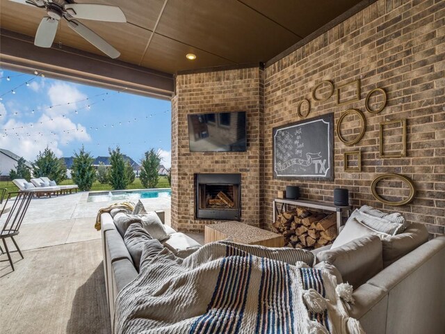 view of patio / terrace featuring ceiling fan and an outdoor living space with a fireplace