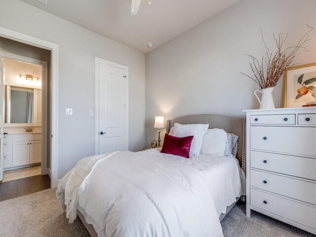 bedroom with ensuite bathroom, sink, and dark hardwood / wood-style floors