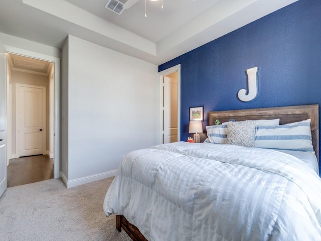 carpeted bedroom with a tray ceiling