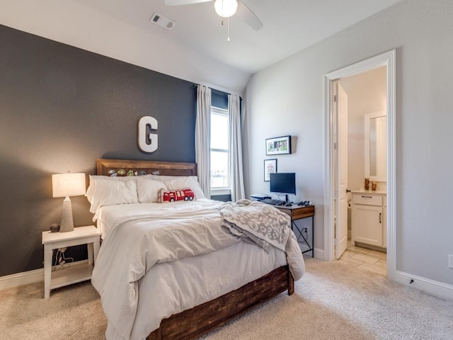 carpeted bedroom featuring vaulted ceiling, connected bathroom, and ceiling fan