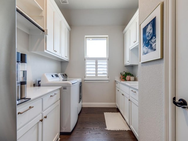 washroom featuring cabinets, sink, dark hardwood / wood-style flooring, and washing machine and dryer