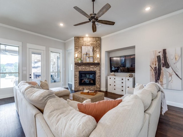 living room with ornamental molding, ceiling fan, a fireplace, and dark hardwood / wood-style flooring