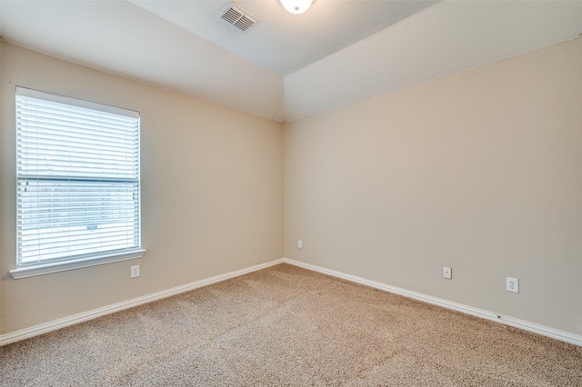 spare room featuring lofted ceiling and carpet flooring