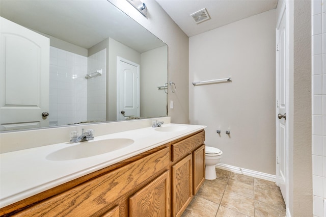 bathroom featuring tile patterned floors, vanity, toilet, and a shower