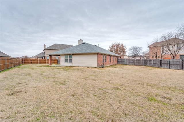 rear view of house featuring a lawn