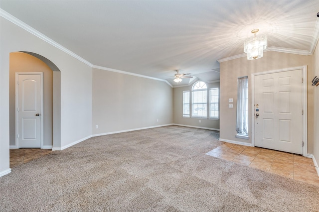 entrance foyer with vaulted ceiling, ceiling fan with notable chandelier, light colored carpet, and crown molding