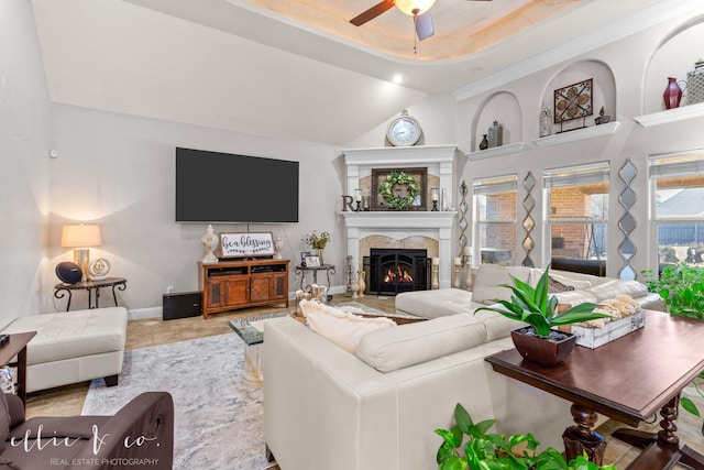 tiled living room featuring ceiling fan and a tray ceiling