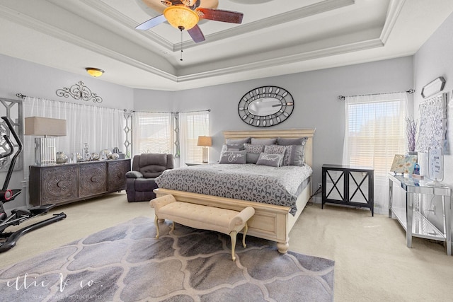 bedroom with ornamental molding, ceiling fan, a raised ceiling, and light colored carpet