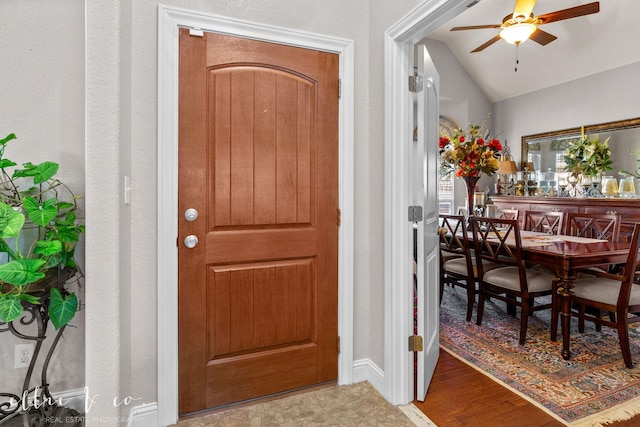 entryway featuring ceiling fan, wood-type flooring, and lofted ceiling