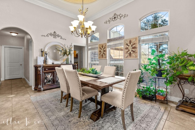 tiled dining space with crown molding, a towering ceiling, and a notable chandelier