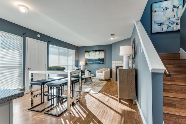 dining room with a tile fireplace and light wood-type flooring