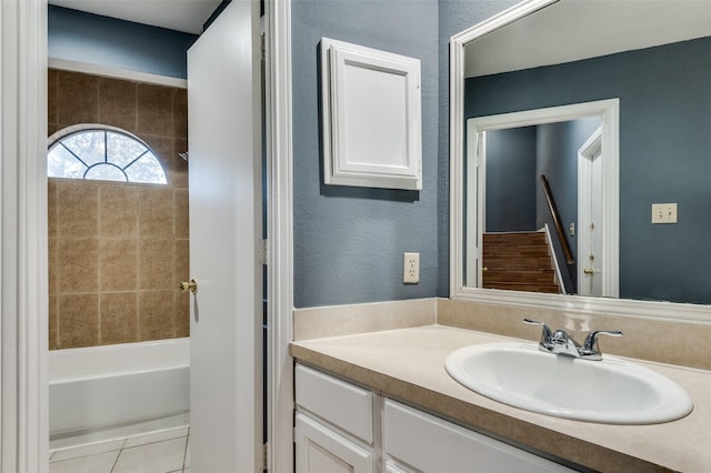 bathroom featuring washtub / shower combination, vanity, and tile patterned flooring