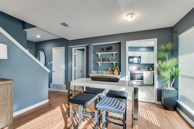 dining room featuring built in features and light wood-type flooring