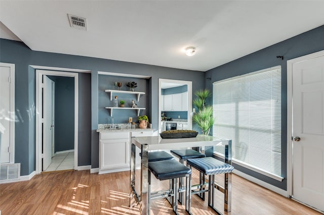 kitchen featuring white cabinetry, light hardwood / wood-style flooring, and a wealth of natural light