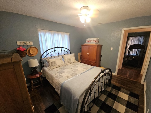 bedroom featuring a textured ceiling, dark hardwood / wood-style floors, and ceiling fan