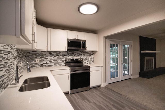 kitchen with white cabinets, stainless steel appliances, tasteful backsplash, and sink