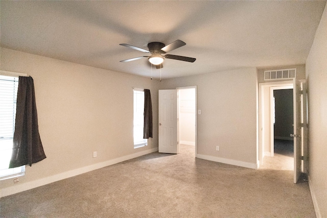 carpeted spare room with ceiling fan