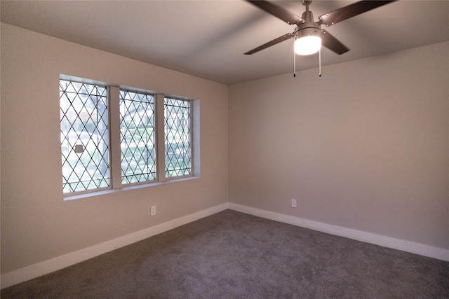 spare room featuring ceiling fan and dark colored carpet