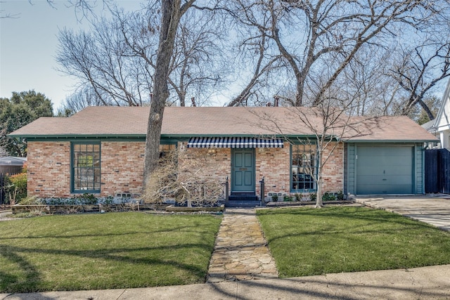 ranch-style home with an attached garage, concrete driveway, brick siding, and a front yard