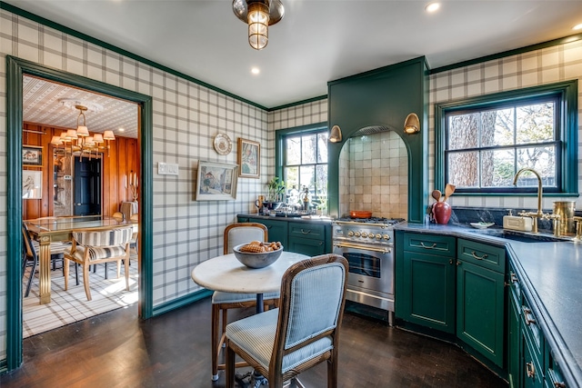 kitchen with crown molding, stainless steel range, dark hardwood / wood-style floors, and pendant lighting