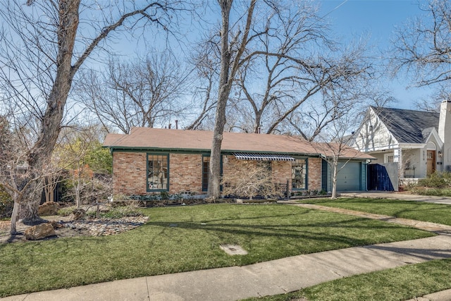 view of front of house featuring a garage, driveway, a front yard, and brick siding