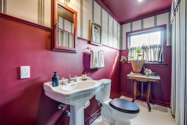 bathroom with tile patterned floors, toilet, and crown molding