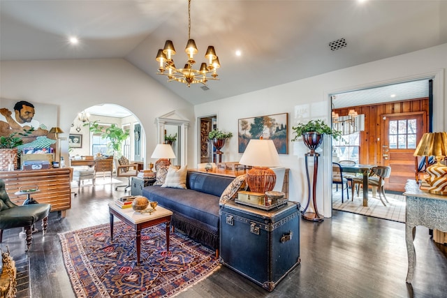 living room featuring a chandelier, a healthy amount of sunlight, wooden walls, and lofted ceiling