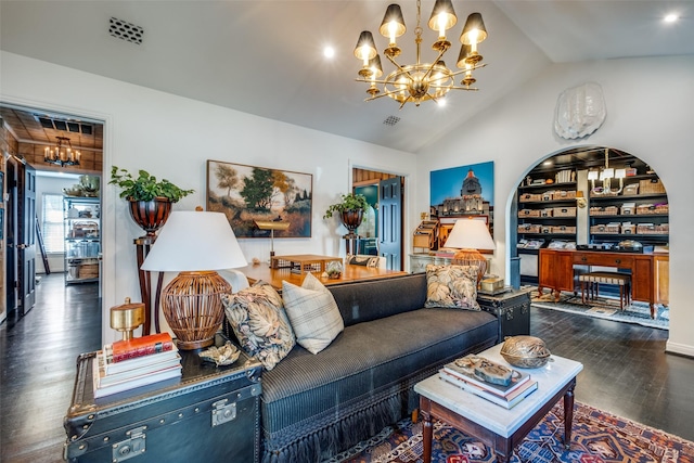 living room with built in shelves, a chandelier, dark hardwood / wood-style floors, and vaulted ceiling