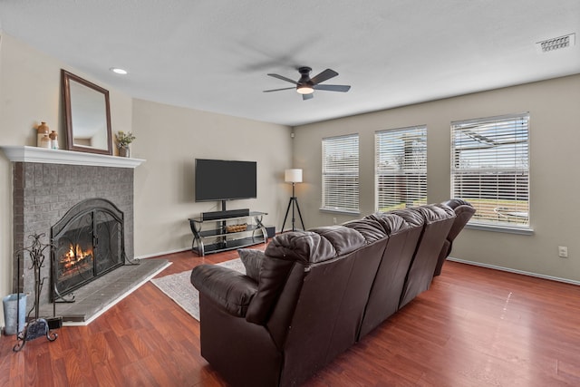 living room featuring ceiling fan, hardwood / wood-style floors, and a fireplace