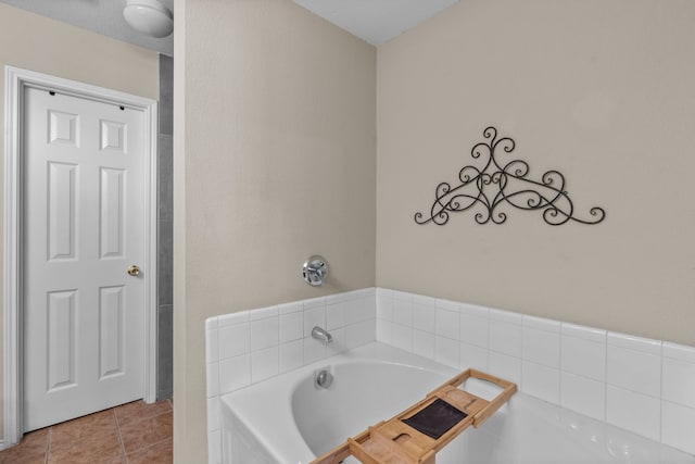 bathroom with tile patterned floors and a tub to relax in