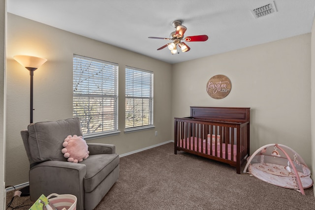 bedroom with ceiling fan, carpet flooring, and a crib