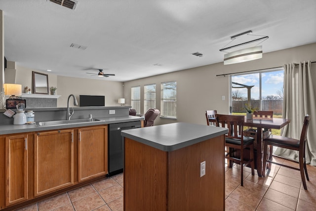 kitchen with a healthy amount of sunlight, a kitchen island, sink, and stainless steel dishwasher