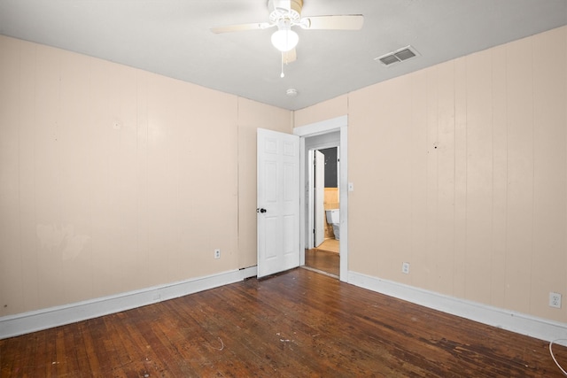 empty room with dark hardwood / wood-style flooring and ceiling fan