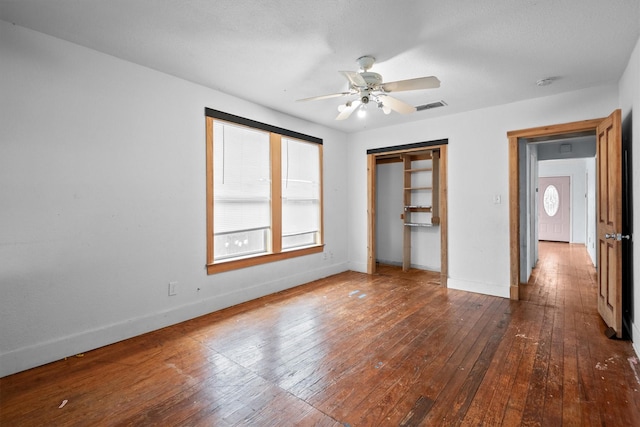 unfurnished bedroom with ceiling fan, wood-type flooring, and a closet