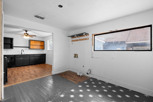 interior space featuring ceiling fan, dark hardwood / wood-style floors, sink, and a textured ceiling