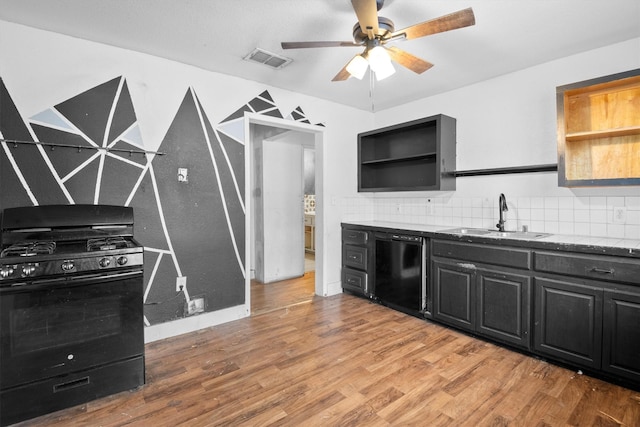 kitchen with hardwood / wood-style floors, sink, decorative backsplash, ceiling fan, and black appliances